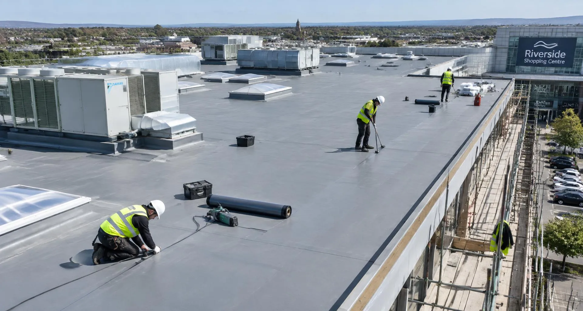Roofers repairing the flat roof of an industrial and shopping centre building