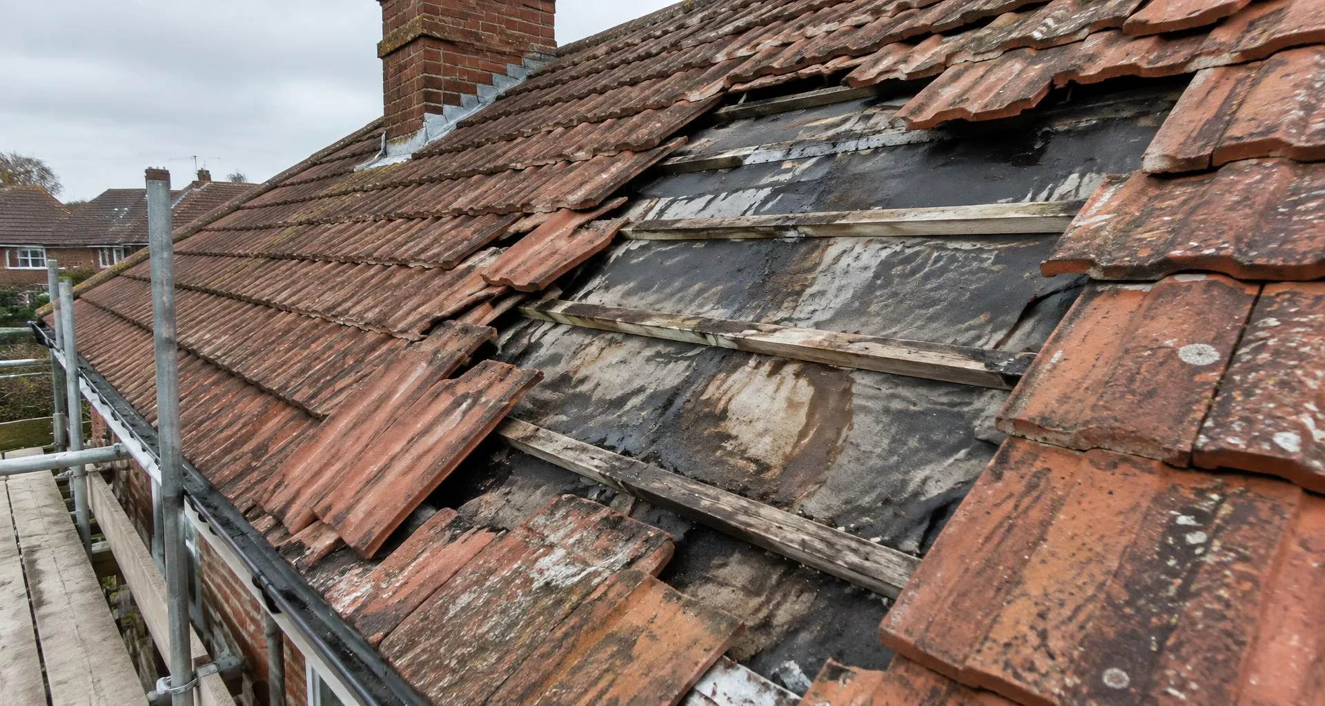 Damaged tiled roof with missing tiles and leak damage